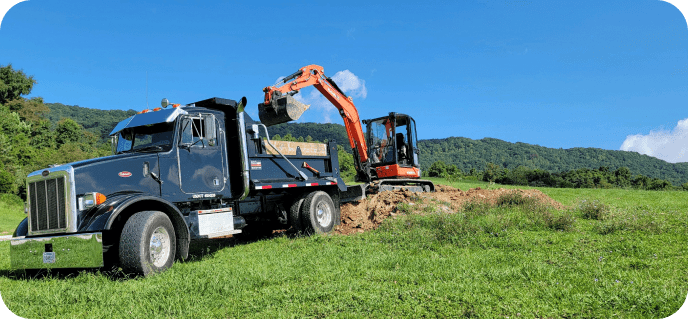 A construction vehicle loading dirt into a dump truck